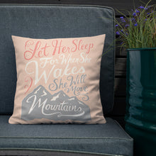 Load image into Gallery viewer, A pink cushion sits on a dark sofa. The cushion reads &#39;Let her sleep for when she wakes she will move mountains&#39; in a pink, white, and light grey lettering design, with a grey mountain illustration at the bottom.