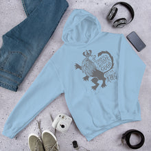 Load image into Gallery viewer, A light blue hoodie laying on the ground with objects around it. The hoodie features hand drawn illustration of the Chronicles of Narnia lion character Aslan. Inside the illustration there is the quote &quot;Course He Isn&#39;t Safe, But He&#39;s Good. He&#39;s the King.&quot;