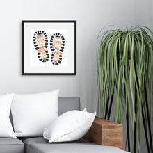 Load image into Gallery viewer, Framed artwork in a black frame on a wall above a grey sofa with a plant next to it. The artwork features illustrated footpritns in black with the words in grey, yellow and orange. The words read &quot;The Lord makes firm the steps of the one who delights in him. Though he may stumble, he will not fall, for the Lord upholds him with his hand.&quot;