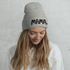 A woman wearing a light grey beanie hat with the word Mama in black lettering with a small heart after the word. This hat is a lovely gift for mothers. 