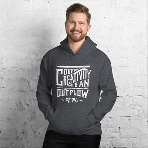 A man wearing a dark grey hoodie with the words "Our creativity is an outflow of His." The words are in white on the hoodie. 