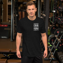 Load image into Gallery viewer, A man wearing a black blue short sleeved t-shirt. The tee features the lettering and illustration in white. The phrase &quot;create, create, create, create, create&quot; is in a small rectangle on the upper left side. 