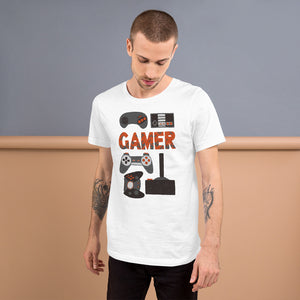 A man wearing a white short sleeved t-shirt. The tee features hand drawn lettering and illustrations featuring different game controllers and the word "gamer." The illustrations and gamer word are in red, grey and black. 