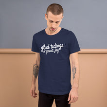 Load image into Gallery viewer, A man wearing a navy blue short sleeved t-shirt. The tee features lettering of the words &quot;glad tidings of great joy.&quot; The words are in white. 