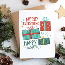 Load image into Gallery viewer, A photo of a Christmas card on top of a brown paper wrapped gift with Christmas decor around it. The card has a white background with the words &quot;Merry Everything and Happy Always.&quot; There are three illustrated Christmas gifts in light red, green and blue with patterns on them.