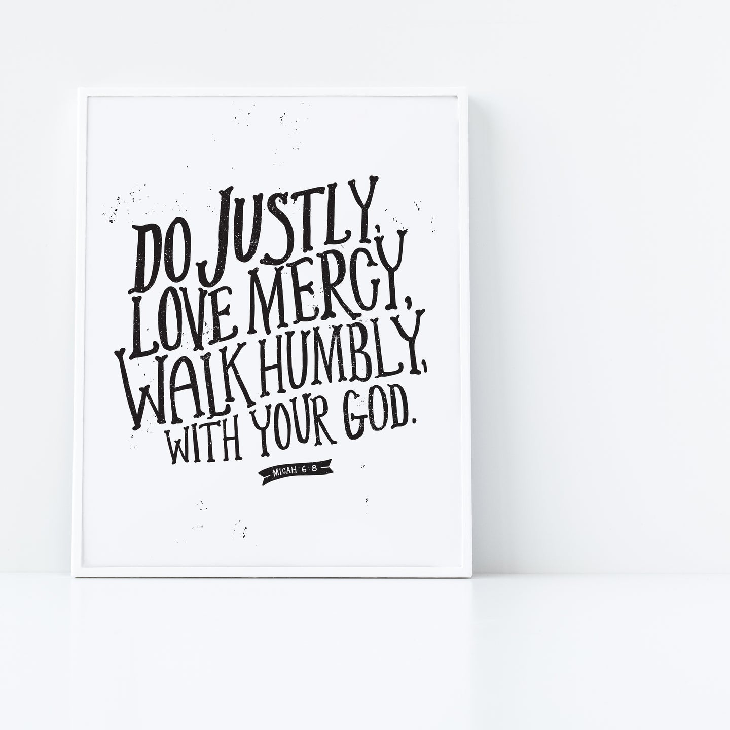 Artwork in a white frame with the artwork printed on white paper and black lettering featuring the Bible verse “Do justly, love mercy, walk humbly, with your God, Micah 6:8.”