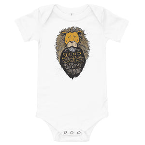 A white baby onesie on a white background. The onesie features an illustration of the Aslan character. Inside the illustration there is the quote “At The Sound of Your Roar, Sorrows Will Be No More.”