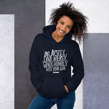 Load image into Gallery viewer, A woman wearing a navy hoodie with the Bible verse words Do justly, love mercy, walk humbly, with your God, Micah 6:8 in white lettering. 