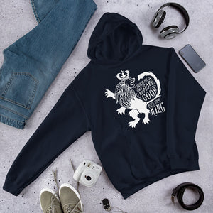 A navy hoodie laying on the ground with objects around it. The hoodie features hand drawn illustration of the Chronicles of Narnia lion character Aslan. Inside the illustration there is the quote "Course He Isn't Safe, But He's Good. He's the King."