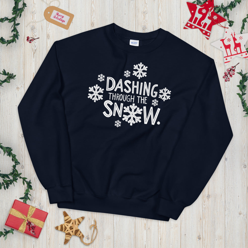 A navy blue sweatshirt laying on a table with Christmas objects around it. The sweatshirt has the words 