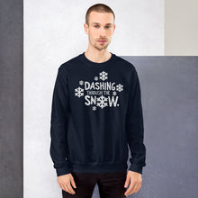 Load image into Gallery viewer, A man wearing a navy blue sweatshirt featuring hand drawn lettering with the words &quot;Dashing through the snow&quot; in white. There are snowflakes around the words. 