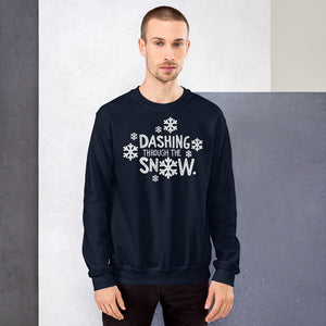 A man wearing a navy blue sweatshirt featuring hand drawn lettering with the words "Dashing through the snow" in white. There are snowflakes around the words. 