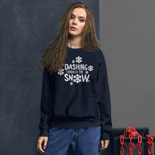 Load image into Gallery viewer, A woman wearing a navy blue sweatshirt featuring hand drawn lettering with the words &quot;Dashing through the snow&quot; in white. There are snowflakes around the words. 