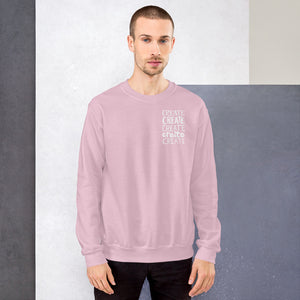 A man wearing a light pink sweatshirt with the word "create, create, create, create, create" in white in a small rectangle on the upper left side.