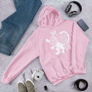 A pink hoodie laying on the ground with objects around it. The hoodie features hand drawn illustration of the Chronicles of Narnia lion character Aslan. Inside the illustration there is the quote "Course He Isn't Safe, But He's Good. He's the King."