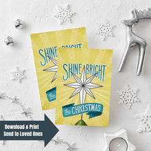 Load image into Gallery viewer, Two Christmas cards laying on a white background with white and silver Christmas decorations on the table. The Christmas card has a yellow background with the words &#39;shine bright this Christmas&#39; in blue and white. There&#39;s an illustrated vintage star Christmas tree topper featured in between the words. In the lefthand lower corner is a navy arrow with the words &quot;download &amp; print, send to loved ones&quot; over the image.
