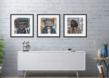 Load image into Gallery viewer, Three black framed prints featuring vintage radios as &quot;heads&quot; on people. The frames are featured above a white cabinet. 