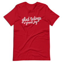 Load image into Gallery viewer, A red T-shirt on a white background. The navy shirt features words in white reading &quot;glad tidings of great joy&quot; in white. 