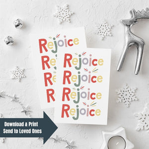 Two Christmas cards laying on a white background with white and silver Christmas decorations on the table. The card has a white background and features the word "rejoice" repeated four times. The letters of the word are in different colors of muted red, yellow, green, purple and pink. The words "download & print, send to loved ones" are in the bottom lefthand corner of the image.