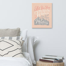 Load image into Gallery viewer, An illustrated pink canvas hangs on a white wall, over a white bed and a stack of books on a bedside table. The canvas reads &#39;Let her sleep for when she wakes she will move mountains&#39; in a pink, white, and light grey lettering design, with a grey mountain illustration at the bottom.