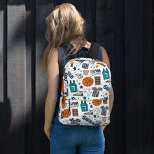 Load image into Gallery viewer, A woman standing in front of a black fence with her back to the camera. She has a backpack over both shoulders, resting on her back. The backpack has a white background with a basketball themed pattern backpack featuring illustrated basketballs, basketball jerseys, whistles, referee shirts, basketball hoops, stars, basketball shoes, fun play sketches and the word &quot;swish.&quot; The backpack straps are black. 