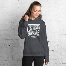 Load image into Gallery viewer, A woman wearing a dark grey hoodie with the words &quot;Our creativity is an outflow of His.&quot; The words are in white on the hoodie. 
