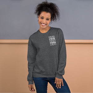 A woman wearing a dark grey sweatshirt with the word "create, create, create, create, create" in white in a small rectangle on the upper left side.