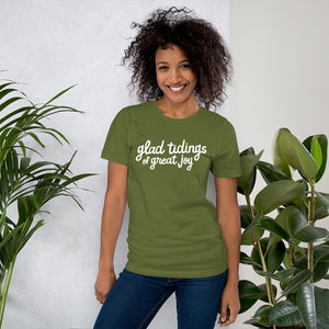 A woman wearing an olive green short sleeved t-shirt. The tee features lettering of the words "glad tidings of great joy." The words are in white. 