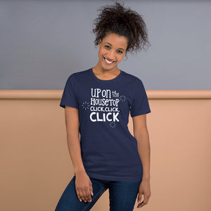 A woman wearing a navy short sleeved t-shirt. The tee features lettering of the words "Up on the housetop, click, click, click." The words are in white with three stars in white surrounding the words. 