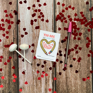 An image of a single classroom Valentine with heart confetti and Valentine’s sweets around it. The design features the words “You are just write”with an illustrated pencil in the shape of a heart.