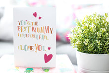 Load image into Gallery viewer, A greeting card is featured on a desktop with a green plant in the background. The card features illustrated lettering reading “You’re the best mummy I could ever have. I love you” with hearts surrounding the words. 